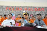 Kapolda Kalbar, Irjen Pol Didi Haryono (tengah) didampingi Direktur Reskrimum Polda Kalbar, Kombes Pol Arif Rachman (kiri) dan Kasat Reskrim Polresta Pontianak, Kompol M Husni Ramli (kanan), memaparkan hasil ungkap kasus di Mapolda Kalbar, Jumat (13/4). Terhitung dari Januari hingga April, Dit Reskrimum Polda Kalbar dan Sat Reskrim Polresta Pontianak berhasil mengungkap 36 dari 41 kasus Curas (pencurian dengan kekerasan) dan membekuk 33 tersangka, serta enam dari sembilan kasus pembunuhan dan membekuk 10 tersangka. ANTARA FOTO/Jessica Helena Wuysang/18