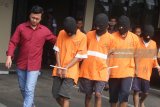 Polisi menggiring empat tersangka komplotan penanam dan pengedar ganja menuju ruang tahanan Mapolresta Malang, Jawa Timur, Selasa (24/4). Dari tangan tersangka, Polisi menyita 37 tanaman ganja siap panen yang sebelumnya ditanam di sebuah kawasan perumahan di Malang. Antara Jatim/Ari Bowo Sucipto/zk/18. 