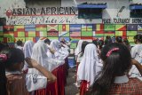 Siswa Sekolah Rakyat Ibu Inggit Garnasih bersama Siswa SDN 249 Astanaanyar melakukan penghormatan kepada 109 bendera peserta Konferensi Asia Afrika saat upacara di Lapangan Aula Kantor RW 05, Kecamatan Astanaanyar, Bandung, Jawa Barat, Rabu (18/4). Upacara yang mengusung tema perdamaian, toleransi, persahabatan, dan solidaritas tersebut dilakukan dalam rangka memperingati Konferensi Asia Afrika ke-63. ANTARA JABAR/Raisan Al Farisi/agr/18