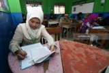 Sejumlah pelajar  berbusana adat tradisional mengikuti Ujian Sekolah Berstandar Nasional (USBN) di SMP Muhammadiyah 11 Surabaya, Jawa Timur, Sabtu (21/4). Kegiatan itu dalam rangka memperingati Hari Kartini. Antara Jatim/Didik Suhartono/zk/18