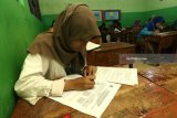 Sejumlah pelajar  berbusana adat tradisional mengikuti Ujian Sekolah Berstandar Nasional (USBN) di SMP Muhammadiyah 11 Surabaya, Jawa Timur, Sabtu (21/4). Kegiatan itu dalam rangka memperingati Hari Kartini. Antara Jatim/Didik Suhartono/zk/18