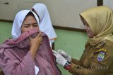 Petugas Dinas Kesehatan (Dinkes) menyuntikkan vaksin DPT (Difteri, Tetanus dan Pertusis) anti penyakit difteri kepada siswa SMAN 1 Ciamis, Jawa Barat, Senin (2/4). Dinas Kesehatan Provinsi Jabar menyasar 3.629.178 warga usia 1-19 tahun untuk mencegah wabah difteri di lima Kota dan Kabuapten yang dianggap rawan, sementara jumlah kasus difteri di Jabar sudah mencapai 123 kasus. ANTARA JABAR/Adeng Bustomi/agr/18