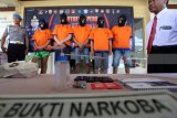 Kepolisian menunjukan barang bukti sabu beserta tersangka saat rilis di Polres Banyuwangi, Jawa Timur, Senin (16/4). Kepolisian Banyuwangi berhasil mengamankan dua WNA asal Amerika dan tiga orang WNI saat pesta narkoba jenis sabu dikawasan wisata Pantai Pulau Merah di Banyuwangi. Antara Jatim/Budi Candra Setya/zk/18.