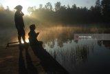 Pengunjung menikmati suasana pagi di kawasan wisata danau Ranu Regulo, Lumajang, Jawa Timur, Sabtu (21/4). Danau yang berada di ketinggian 2100 diatas permukaan laut (dpl) tersebut merupakan salah satu tempat favorit para pendaki untuk beristirahat sebelum melanjutkan perjalanan ke puncak Gunung Semeru. Antara Jatim/Ari Bowo Sucipto/zk/18.