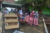 Sejumlah anak membaca buku yang disediakan oleh Perpustakaan Keliling Becak di Desa Sukaraja Kulon, Jatiwangi, Kabupaten Majalengka, Jawa Barat, Minggu (1/4). Perpustakaan keliling tersebut bertujuan untuk mengingatkan masyarakat khususnya anak-anak untuk terus membaca. ANTARA FOTO/Agvi Firdaus/pras/18