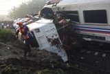 Petugas menyaksikan lokomotif KA Sancaka yang kecelakaan di Ngawi, Jawa Timur, Sabtu (7/4). Peristiwa tabrakan Kereta Sancaka dengan truk trailer tersebut menyebabkan seorang masinis kereta itu meninggal.   (ANTARA FOTO/Zabur Karuru)