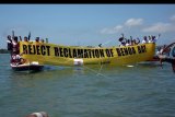 Massa yang tergabung dalam Forum Rakyat Bali Tolak Reklamasi (ForBali) dan Greenpeace melakukan aksi Tolak Reklamasi Teluk Benoa di kawasan perairan Teluk Benoa, Bali, Sabtu (14/4). Mereka melakukan aksi dengan mengelilingi perairan Teluk Benoa sambil membentangkan spanduk menuntut pemerintah membatalkan Peraturan Presiden No 51/2014 yang dinilai akan dapat dijadikan dasar hukum reklamasi dan pemanfaatan Teluk Benoa oleh investor. ANTARA FOTO/Wira Suryantala/wdy/2018