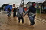 Sejumlah warga berjalan kaki saat kampung mereka terendam banjir di Kampung Kramatwatu, Serang, Banten, Rabu (25/4). Banjir terjadi akibat penggundulan hutan secara masif di Bukit Panenjoan hingga Gunung Pinang sehingga air meluap setelah terjadi hujan deras selama dua hari di daerah itu. ANTARA FOTO/Asep Fathulrahman/ama/18