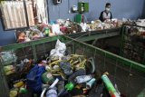 Sejumlah pekerja memilah sampah non organik dan barang bekas beracun (B3) pada mesin konveyor di Pusat Daur Ulang Sampah Jambangan, Surabaya, JawaTimur, Sabtu (14/4). Pusat Daur Ulang tersebut mengolah tiga hingga lima ton sampah pada satu hari tersebut 40 persen merupakan sampah organik sisa dapur diproses menjadi kompos dan 20 persen non organik di jual pada pengepul.  (ANTARA FOTO/M Risyal Hidayat)