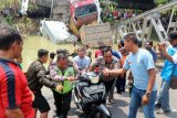 Petugas bersama warga mengevakuasi sepeda motor yang tercebur dalam kejadian runtuhnya jembatan Widang, di Tuban, Jawa Timur, Selasa (17/4). Sisi barat jembatan itu runtuh sekitar 50 meter dan mengakibatkan satu pengemudi truk meninggal dunia, dan melukai tiga korban lainnya, sementara tiga truk dan sebuah sepeda motor masuk ke Bengawan Solo. ANTARA FOTO/Aguk Sudarmojo/foc/17.