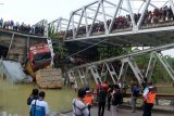 Warga mengerumuni lokasi jembatan Widang yang runtuh, Tuban, Jawa Timur, Selasa (17/4). Sisi barat jembatan itu runtuh sekitar 50 meter dan mengakibatkan satu pengemudi truk meninggal dunia, dan melukai tiga korban lainnya, sementara tiga truk dan sebuah sepeda motor masuk ke Bengawan Solo.  (ANTARA FOTO/Aguk Sudarmojo)