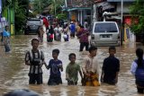 Sejumlah warga keluar rumah menuju tempat pengungsian setelah kampung mereka terendam banjir di Kampung Cibeber, Cilegon, Banten, Rabu (25/4). Banjir terjadi akibat penggundulan hutan secara masif di Bukit Panenjoan hingga Gunung Pinang sehingga air meluap setelah terjadi hujan deras selama dua hari di daerah itu. ANTARA FOTO/Asep Fathulrahman/ama/18