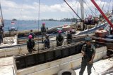 Petugas Polisi Kehutanan dibantu personel Marinir berjaga di atas dua unit kapal masing-masing, KLM Arjuna Putra 04 dan KLM Sinar Maros yang berlabuh di perairan Sorong, Kota Sorong, Papua Barat, Selasa (10/4). Operasi Bersama Kementerian Lingkungan Hidup dan Kehutanan (KLHK), Lantamal XIV dan Dirjen Perhubungan Laut Sorong berhasil mengamankan dua unit kapal bermuatan 223 meter kubik kayu jenis Merbau siap kirim yang diperoleh dari penebangan liar di kawasan cagar alam Salawati Utara, Raja Ampat.  (ANTARA FOTO/Olha Mulalinda)