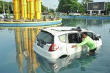 Seorang petugas memeriksa kondisi mobil yang tercebur ke kolam air mancur Tugu Digulis di kawasan Universitas Tanjungpura Pontianak, Kalbar, Jumat (6/4). Mobil tersebut menabrak pembatas jalan dengan kecepatan tinggi, dan masuk ke kolam pada Jumat (6/4) dini hari pukul 02.30 wib, meski tidak ada korban jiwa dalam peristiwa itu.   (ANTARA FOTO/Jessica Helena Wuysang)