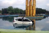 Sebuah mobil Honda Jazz dengan nopol KB 1068 SN berada di dalam kolam air mancur Tugu Digulis, Pontianak, Kalbar, Jumat (6/4). Mobil tersebut melompat masuk ke kolam saat mengalami kecelakaan tunggal yang terjadi pada Jumat (6/4) dini hari pukul 02.30 wib.  ANTARA/Jessica Helena Wuysang/18