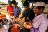 Sejumlah imigran gelap etnis Rohingya asal Myanmar mengambil makanan antrean di dapur umum penampungan darurat komplek Sanggar Kegiatan Belajar (SKB) Cot Gapu Kabupaten Bireuen, Aceh, Sabtu (21/4). Pemerintah setempat melalui Dinas sosial dibantu Tagana dan Badan Penanggulangan Bencana Daerah (BPBD) membuka dapur umum untuk memenuhi hak dasar bagi para pengungsi Rohingya yang tampung sementara di wilayah Indonesia. ANTARA FOTO/Rahmad/pd/18