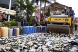 Wakapolda Lampung Brigjen Pol. Angesta Romano Yoyol bersama Plt Walikota Bandar Lampung Yusuf Kohar naik alat berat ketika memusnahkan barang bukti ribuan botol minuman keras (miras) di Mapolresta Bandar Lampung, Jumat (20/4). Pemusnahan sebanyak 1.442 botol miras berbagai merk dan 2.507 liter tuak itu merupakan hasil penindakanan Operasi Cipta Kondisi selama tiga hari.  (ANTARA FOTO/Ardiansyah)