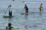 Sejumlah wanita dan wisatawan mancanegara mengenakan kebaya mendayung 'paddle board' saat mengikuti peringatan Hari Kartini di kawasan Pantai Sanur, Bali, Sabtu (21/4). Kegiatan tersebut digelar selain untuk memperingati Hari Kartini sekaligus mengenalkan sejarah bangsa Indonesia khususnya perjuangan RA Kartini kepada wisatawan mancanegara. ANTARA FOTO/Fikri Yusuf/wdy/2018