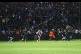 Suporter memasuki lapangan saat terjadi kericuhan pada pertandingan antara Arema FC melawan Persib Bandung dalam Liga I di Stadion Kanjuruhan, Malang, Jawa Timur, Minggu (15/4). Kericuhan tersebut menyebabkan sejumlah suporter luka-luka. ANTARA FOTO/H Prabowo/abs/kye/18