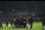 Suporter memasuki lapangan saat terjadi kericuhan pada pertandingan antara Arema FC melawan Persib Bandung dalam Liga I di Stadion Kanjuruhan, Malang, Jawa Timur, Minggu (15/4). Kericuhan tersebut menyebabkan sejumlah suporter luka-luka. ANTARA FOTO/H Prabowo/abs/kye/18