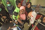 Imigran etnis Rohingya yang terdampar, Kamal Husen (8th) bersiap dibaringkan oleh ibunya saat menjalani perawatan intensif di Rumah Sakit Zubir Mahmud, Idi, Aceh Timur, Aceh, Jumat (6/4). Sedikitnya 5 dari sepuluh imigran muslim Rohingya dua laki-laki, dua wanita dan satu anak bernama Kamal Husen (8th), Mursyidik (28), M. Ilyas (33), Syamimah (15) dan Mominah (20) ditemukan terdampar sekitar 176 mil dari perairan lepas Aceh Timur saat menggunakan Kapal tanpa mesin.  (ANTARA FOTO/Rahmad)