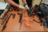 Polisi menunjukkan sejumlah amunisi dan senjata rakitan yang disita dari warga di Mapolres Sigi, Sulawesi Tengah, Sabtu (28/4). Polres Sigi berhasil menyita puluhan senjata rakitan dari warga Desa Binangga dan Baliase yang bertikai hingga menyebabkan seorang tewas. ANTARAFOTO/Basri Marzuki/Spt/18