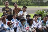 Presiden Joko Widodo (kiri) didampingi Ibu Negara Iriana Joko Widodo dan anak-anak penderita kanker pendampingan Yayasan Kanker Anak Indonesia tertawa saat menyaksikan pertunjukan sulap disela-sela silaturahmi di halaman belakang Istana Bogor, Jawa Barat, Jumat (6/4). Yayasan Kanker Anak Indonesia dalam kesempatan tersebut meminta regulasi impor obat kanker dipermudah dan bea masuk ditiadakan. ANTARA FOTO/Puspa Perwitasari/wdy/2018