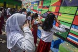 Siswa Sekolah Rakyat Ibu Inggit Garnasih bersama Siswa SDN 249 Astanaanyar mengikuti upacara di Lapangan Aula Kantor RW 05, Kecamatan Astanaanyar, Bandung, Jawa Barat, Rabu (18/4). Upacara yang mengusung tema perdamaian, toleransi, persahabatan, dan solidaritas tersebut dilakukan dalam rangka memperingati 63 tahun Konferensi Asia Afrika.  (ANTARA FOTO/Raisan Al Farisi)