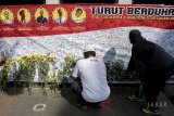 Warga meletakkan bunga sebagai bentuk belasungkawa pada kegiatan solidaritas untuk Kepolisian Republik Indonesia di Car Free Day Dago, Bandung, Jawa Barat, Minggu (13/5). Aksi yang digagas Kepolisian Daerah Jawa Barat tersebut guna mengajak partisipasi, empati dan simpati masyarakat atas meninggalnya enam anggota kepolisian pada peristiwa kerusuhan Mako Brimob serta bersikap dan mendukung gerakan untuk tidak takut terhadap aksi terorisme. ANTARA JABAR/Novrian Arbi/agr/18