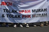 Buruh dari berbagai serikat pekerja berunjuk rasa peringati Hari Buruh Se Dunia di depan Gedung Negara Grahadi di Surabaya, Jawa Timur, Selasa (1/5). Dalam aksi tersebut para buruh mengajukan berbagai tuntutan diantaranya mencabut PP 78/2015 tentang Pengupahan dan penerapan Upah Minimum Nasional sebagai sistem pengupahan Indonesia. Antara Jatim/Moch Asim/zk/18