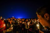 Warga dari berbagai elemen menyalakan lilin saat melakukan aksi seribu lilin di Lapangan Gasibu, Bandung, Jawa Barat (13/5) malam. Aksi seribu lilin tersebut dilakukan sebagai dukungan dan doa bagi korban bom di tiga gereja yang terjadi di Surabaya. ANTARA JABAR/Raisan Al Farisi/agr/18