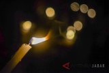 Warga dari berbagai elemen menyalakan lilin saat melakukan aksi seribu lilin di Lapangan Gasibu, Bandung, Jawa Barat (13/5) malam. Aksi seribu lilin tersebut dilakukan sebagai dukungan dan doa bagi korban bom di tiga gereja yang terjadi di Surabaya. ANTARA JABAR/Raisan Al Farisi/agr/18