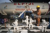 Pekerja melakukan pengisian LPG ke dalam truk pengangkut LPG atau 