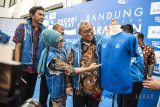 Gubernur Jawa Barat Ahmad Heryawan (kanan) didampingi Kepala Dinas Pariwisata dan Kebudayaan, Ida Hernida (kedua kiri) dan Wapimdiv Coorporate Secretary bank BJB Widi Hartoto (kiri) melihat jersey Bandung West Java Marathon 2018 di Gedung Sate, Bandung, Jawa Barat, Kamis (31/5). Kegiatan tersebut merupakan ajang lari berkeliling kota dengan konsep 