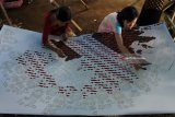 Pekerja menyelesaikan proses pewarnaan batik di industri rumahan 