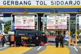 Tim Gegana Sat Brimob Polda Jawa Timur bersiap menjinakan sebuah benda yang diduga bom di loket Pintu masuk Tol Sidoarjo, Jawa Timur, Jumat (18/5). Benda yang dicurigai bom tersebut diledakkan oleh tim Gegana Sat Brimob Polda Jawa Timur. Antara Jatim/Umarul Faruq/zk/18