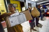 Petugas Dinas Pendidikan Kota Bandung menurunkan paket soal di titik pendistribusian soal Ujian Sekolah Berstandar Nasional (USBN) Sekolah Dasar di SMPN 5 Bandung, Jawa Barat, Senin (30/4/2018) malam. Dinas Pendidikan Kota Bandung mendistribusikan 39.684 soal untuk dibagikan kepada 276 SD Negeri dan 250 SD Swasta di Kota Bandung untuk mengikuti USBN yang akan dilaksanakan pada tanggal 3 hingga 5 Mei mendatang. (ANTARA /Raisan Al Farisi) 