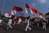 Sejumlah pelajar berlari sambil membawa bendera merah putih saat Upacara Hari Jadi Kota Surabaya ke-725 di Taman Surya, Surabaya, Jawa Timur, Kamis (31/5). Dalam upacara tersebut juga ditampilkan sejumlah hiburan dan Tari Remo kolosal dengan jumlah penari sebanyak 725 penari gabungan dari SD se-Surabaya. Antara Jatim/Zabur Karuru/18