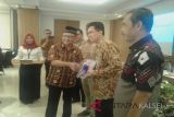 Kepala Perwakilan Bank Indonesia Perwakilan Kalimantan Selatan Herawanto Menyerahkan Cendera Mata Kepada Peserta Diseminasi Laporan Perekonomian Indonesia 2017, di Hotel Treepark Banjarmasin, Senin (21/5).Foto:Antaranews Kalsel/Arianto.