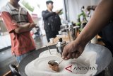 Barista memasak kopi di atas pasir saat kegiatan West Java Coffee & Art dan HUT ke-57 Bank BJB di Bandung, Jawa Barat, Jumat (11/5). Kegiatan yang melibatkan petani kopi Jabar, petani teh, pegiat ecovillage sungai Citarum, para pelaku usaha kecil dan menengah, komunitas hobi, dan komunitas seni budaya Jawa Barat akan berlangsung hingga Minggu, 13 Mei 2018. ANTARA JABAR/M Agung Rajasa/agr/18
