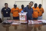 Polisi menunjukan barang bukti dan tersangka saat rilis pengungkapan kasus jaringan penipuan di Polresta Yogyakarta, Rabu (2/5/2018). Saat ini tim Polresta Yogyakarta berhasil mengamankan uang mainan (palsu) dengan nominal mencapai Rp900 juta dan lima tersangka dalam kasus jaringan penipuan pinjaman uang dengan modus, tersangka menjanjikan pinjaman uang dan korban harus membayar administrasi, sementara yang diberikan oleh tersangka adalah uang palsu. (ANTARA /Andreas Fitri Atmoko) 