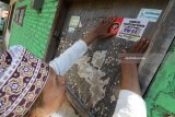 Warga menempel stiker larangan merokok di salah satu rumah di Kelurahan Kampung Dalem, Kota Kediri, Jawa Timur, Kamis (31/5). Melalui kesepakatan warga, seluruh rumah di lingkungan Rukun Warga (RW) di kawasan tersebut bebas asap rokok guna mendukung program nasional Gerakan Masyarakat Hidup Sehat (Germas). Antara Jatim/Prasetia Fauzani/zk/18