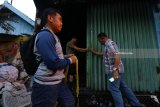 Polisi berpakaian sipil memasang garis polisi pada rumah yang terbakar di Jalan Kebalen Kulon 2 no 9, Surabaya, Jawa Timur, Selasa (29/5). Kebakaran rumah indekos tersebut menelan 8 korban meninggal. Antara jatim/Didik Suhartono/zk/18