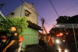 Teknisi PLN memotong kabel listrik yang melintang pada rumah yang terbakar di Jalan Kebalen Kulon 2 no 9, Surabaya, Jawa Timur, Selasa (29/5). Kebakaran rumah indekos tersebut menelan 8 korban meninggal. Antara Jatim/Didik Suhartono/zk/18