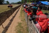 Pengunjung menonton kejuaraan kerapan sapi di Desa Durbuk, Pamekasan, Minggu (13/5). Kerapan sapi se Madura tersebut diikuti sedikitnya 80 pasang sapi. Antara Jatim/Saiful Bahri/mas/18.