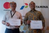 Commercial Retail Fuel Marketing Manager PT Pertamina (Persero) Deny Djukardi (kiri) dan Direktur Mastercard Indonesia Tommy Singgih (kanan) berfoto bersama usai menandatangani dokumen kerja sama di Jakarta, Senin (14/5/2018). Pertamina menjalin kerja sama dengan Mastercard guna menunjang sistem pembayaran elektronik (nontunai) untuk transaksi di seluruh Stasiun Pengisian Bahan Bakar Umum (SPBU) Pertamina di Indonesia. (ANTARA FOTO/Widodo S Jusuf) 