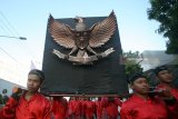 Sejumlah pelajar membawa lambang Garuda Pancasila saat Kirab Grebeg Pancasila di Blitar, Jawa Timur, Kamis (31/5). Selain dalam rangka memperingati hari lahir Pancasila yang jatuh pada 1 Juni, kirab yang diikuti oleh sejumlah seniman, pelajar, dan masyarakat tersebut juga bertujuan untuk meningkatkan semangat nasionalisme dan cinta tanah air yang terkandung dalam Pancasila dan UUD 1945.Antara/Irfan Anshori/18