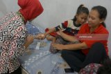 Petugas menyuntikkan obat melalui slang infus salah satu pasien korban keracunan makanan di RS Bhayangkara, Tulungagung, Jawa Timur, Rabu (30/5). Pasien bersama enam saudaranya mengalami keracunan makanan usai berbuka bersama di sebuah kafe setempat pada Selasa (29/5) sehingga harus menjalahi rawat intensif di ruang rawat inap Mawar, RS Bhayangkara karena terus mengalami mual dan muntah. Antara jatim/Destyan Sujarwoko/zk/18