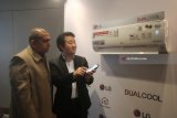 Manager Air Solution B2C Asia/China LG Electronics Yoong Jung June (kanan) dan Branch Manager LG Electronics Indonesia wilayah Surabaya Irvan Salahudin (kiri) menyalakan pendingin udara melalui ponsel saat acara pengenalan AC Inverter LG Dual Cool di Surabaya, Jawa Timur, Kamis (3/5). PT LG Electronics Indonesia memperkenalkan produk terbaru pendingin udara yakni AC Inverter LG Dual Cool Series. Selain lebih cepat dingin dan hemat daya listrik, AC LG Dual Cool Series memiliki fitur SmartThinQ yang dapat memudahkan pengguna untuk pengaturannya melalui smartphone. Antara Jatim/Moch Asim/zk/18