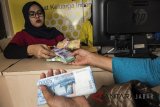 Pegawai Bank melayani warga yang menukarkan uang di loket mobil kas keliling saat pembukaan layanan penukaran uang di Bandung, Jawa Barat, Senin (21/5). Bank Indonesia Kantor Perwakilan Wilayah Jawa Barat memproyeksikan kebutuhan uang Ramadan tahun 2018 berjumlah Rp11,92 triliun, meningkat sebesar Rp440 miliar atau 3,8 persen dibandingkan realisasi pemenuhan kebutuhan Ramadan tahun lalu sebesar Rp11,48 triliun. ANTARA JABAR/M Agung Rajasa/agr/18
